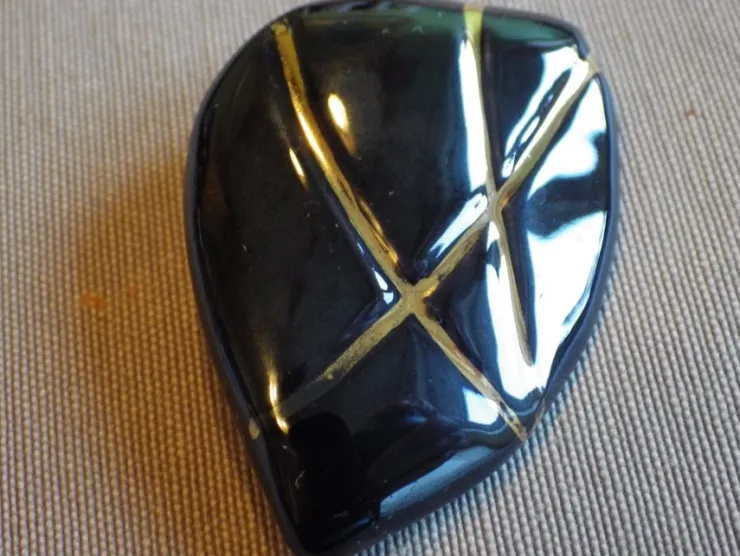 Tradera Äldre vacker Brosch i glaserad porslin, svart med gulddekor. 50-tal> Brocher