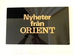 Tradera Nyheter från Orient.Hårdplast. Svart och guld. Skyltställ från -70talet.46x28> Andet Urrelateret
